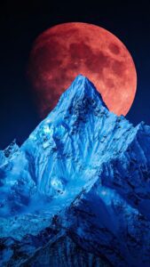 Snow covered blue mountain red moon wallpaper